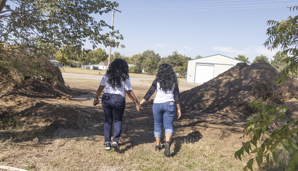 Rene Elmore and Shelby Ronea walk hand-in-hand on their ancestors' homestead